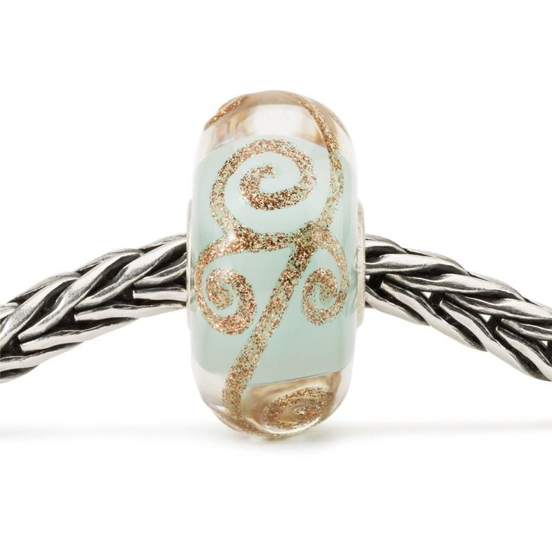 Perle Trollbeads Histoire d'amour en verre enfilée sur un bracelet Trollbeads en argent.