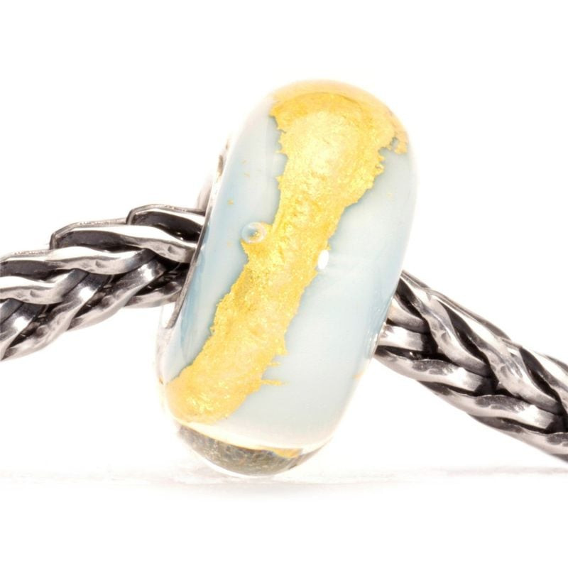 Perle Trollbeads Or bleu clair en verre bleu pâle, volute dorée, enfilée sur un bracelet chaîne en a