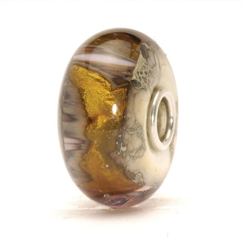 Perle Trollbeads Grotte en or en verre, debout sur fond blanc, révélant feuille d'or 22 carats et vo