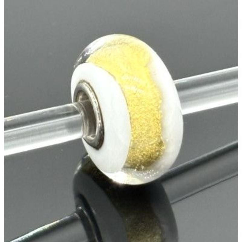 Perle Trollbeads Chakra Couronne enfilée sur une tige de verre transparent, reflet sur une surface n