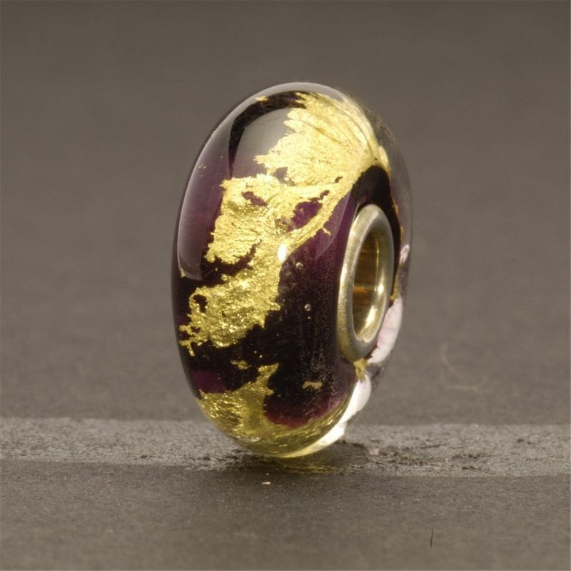 Perle Trollbeads Troisième œil artisanale sur ardoise grise, verre violet et feuille d'or 22 carats