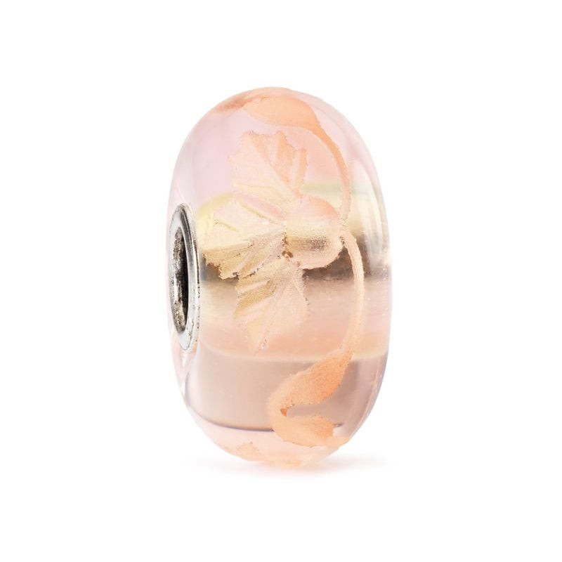 Perle en verre Trollbeads Romance gravée avec de délicates gravures florales sur fond blanc.