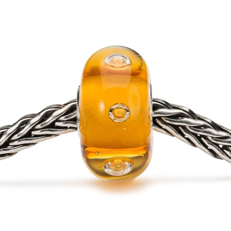 Perle de verre SIENNA Bubble Joy enfilée sur une chaîne Trollbeads en argent, aux teintes ambrées ch