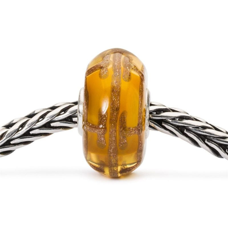 Perle de verre ambre Série Rêverie Dream Blaze enfilée sur une chaîne Trollbeads en argent, aux refl
