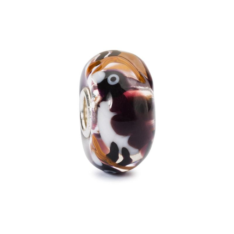 Perle en verre Trollbeads faite main, oiseau sombre et détails blancs sur fond neutre, finition bril