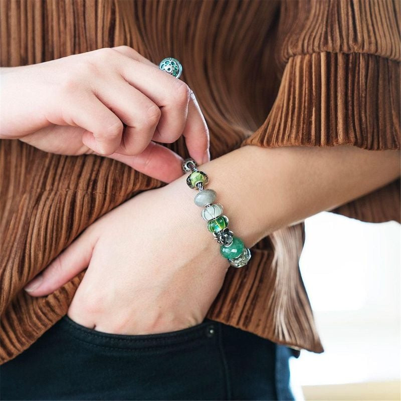 Femme portant un bracelet Trollbeads avec la Perle Trollbeads Série Aurore Tulipe Verre Blanc
