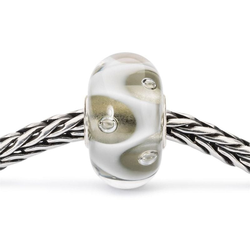 Perle de charme en verre Trollbeads Drops of White enfilée sur un bracelet Trollbeads en argent tres