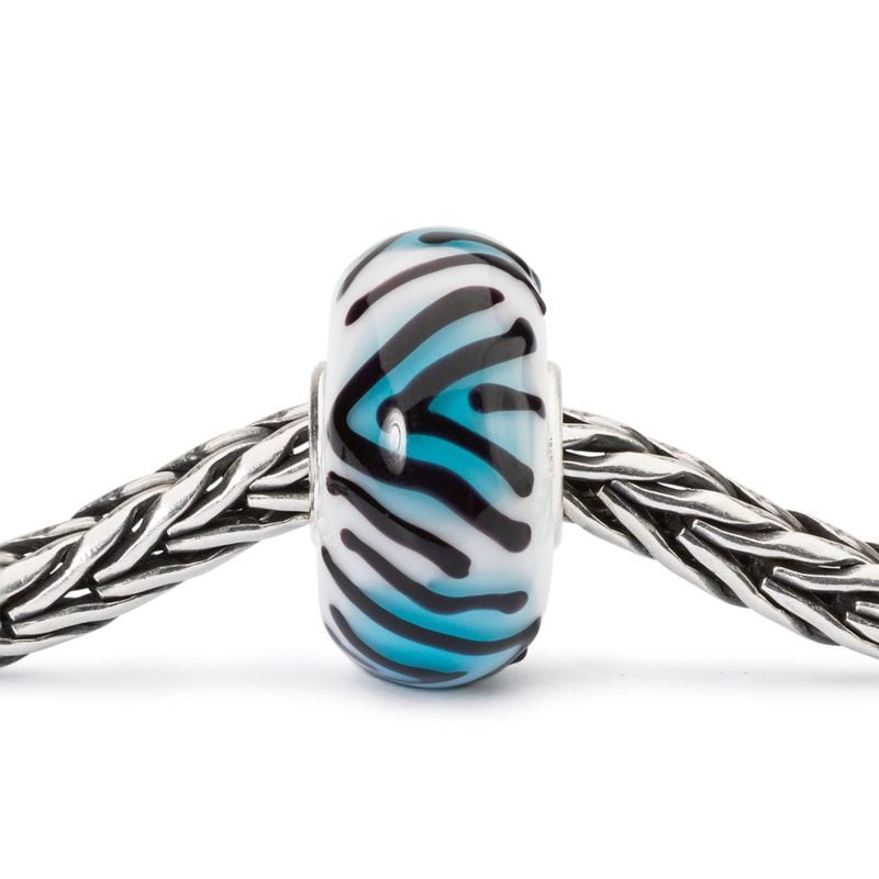 Gros plan de la perle en verre Trollbeads Tigre de topaze enfilée sur une chaîne en argent sterling 