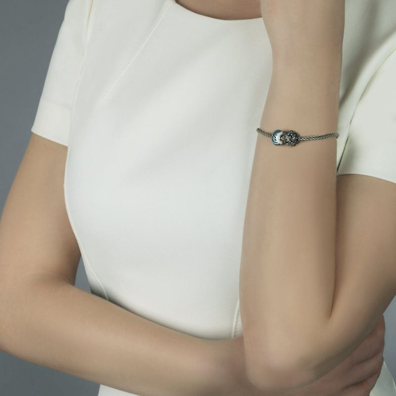 Femme portant un bracelet en argent Trollbeads avec la perle en verre Tigre de topaze au poignet