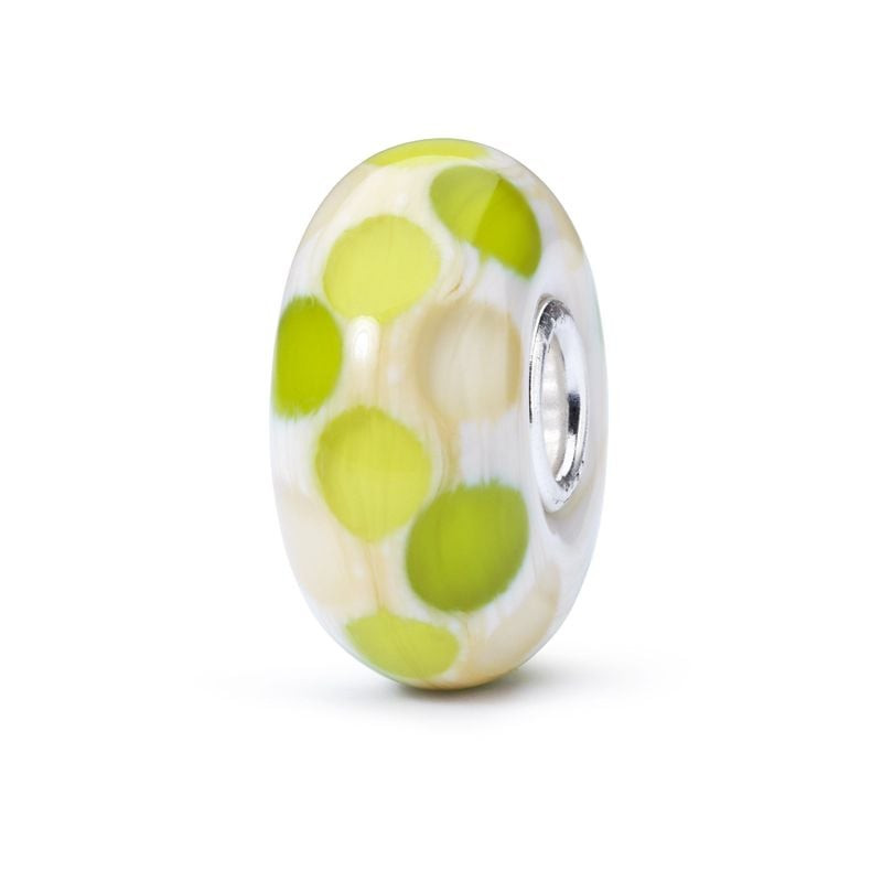 Perle de verre Trollbeads Sommeil à pois vert lime sur fond blanc crème, présentée debout sur fond b