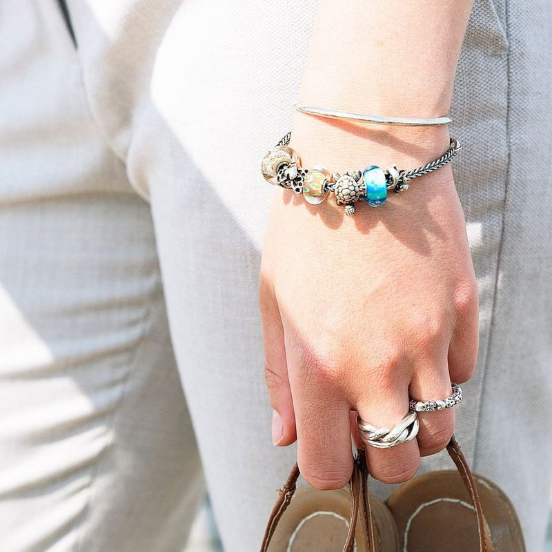 Gros plan sur la Perle TROLLBEADS Il Était Une Fois Verre Orange en verre soufflé, portée sur un bra