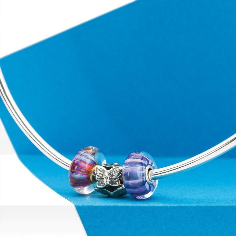 Perle de verre violette Lignes violettes sur un jonc argent avec breloque papillon et perle aux tons