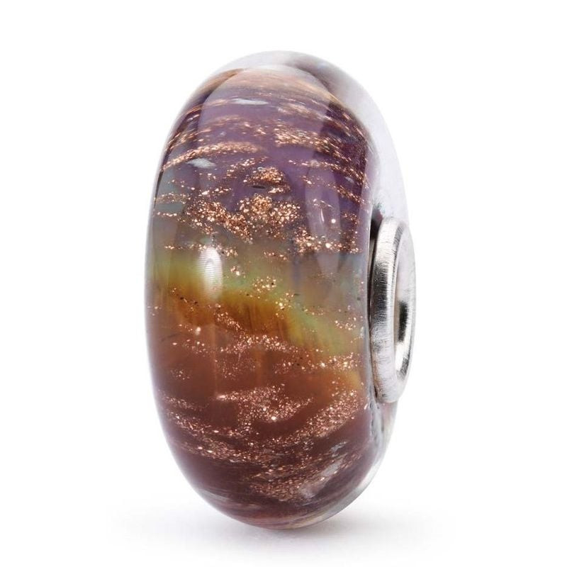 Gros plan sur la perle Trollbeads Arc-en-ciel de chance en verre violet profond, marron et vert, âme