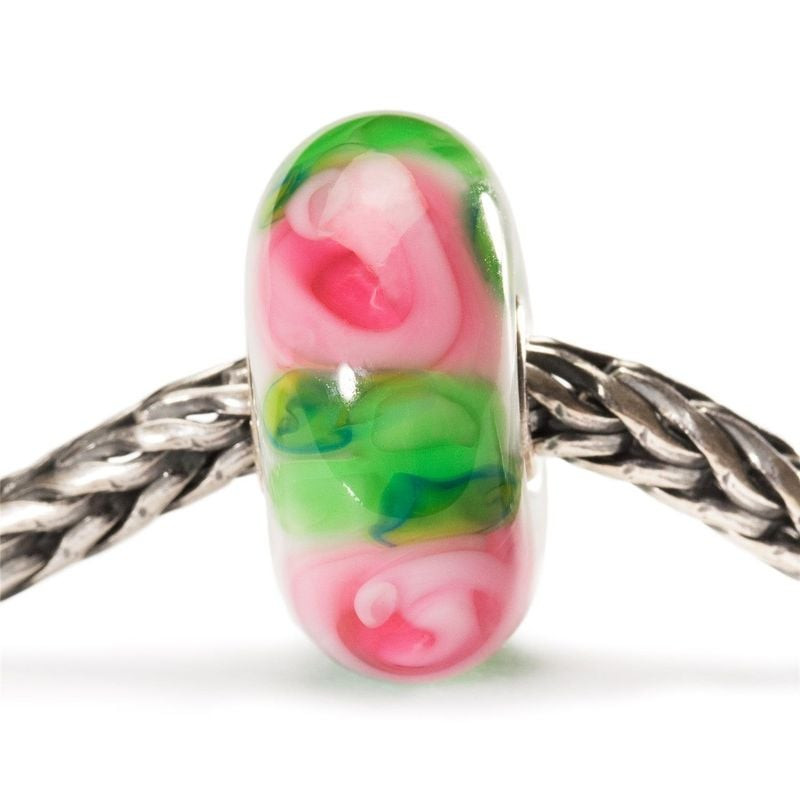 Perle de verre Trollbeads Rose aux pétales roses et verts enfilée sur une chaîne de bracelet Trollbe