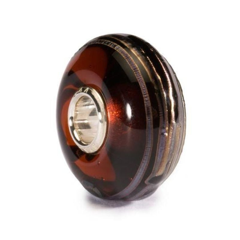 Gros plan de la perle de charme Trollbeads Fil d'or brun en verre, surface bordeaux brillante et âme