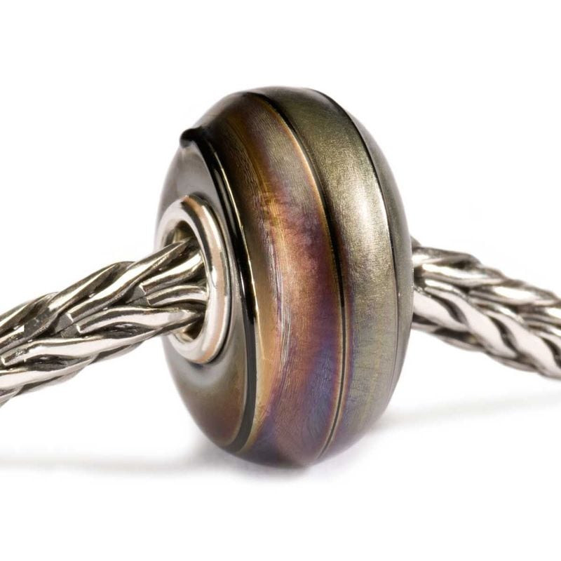 Perle Trollbeads Soie noire enfilée sur un bracelet Trollbeads en argent, dévoilant un verre noir et