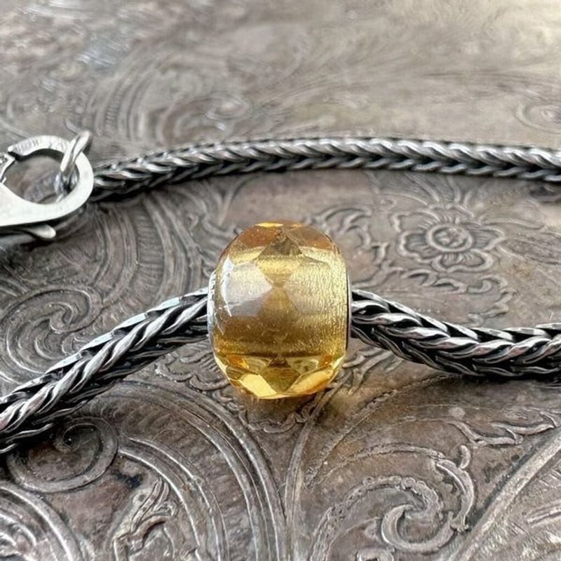 Perle Trollbeads Prisme jaune en verre facetté avec cœur en argent sterling sur un bracelet en argen
