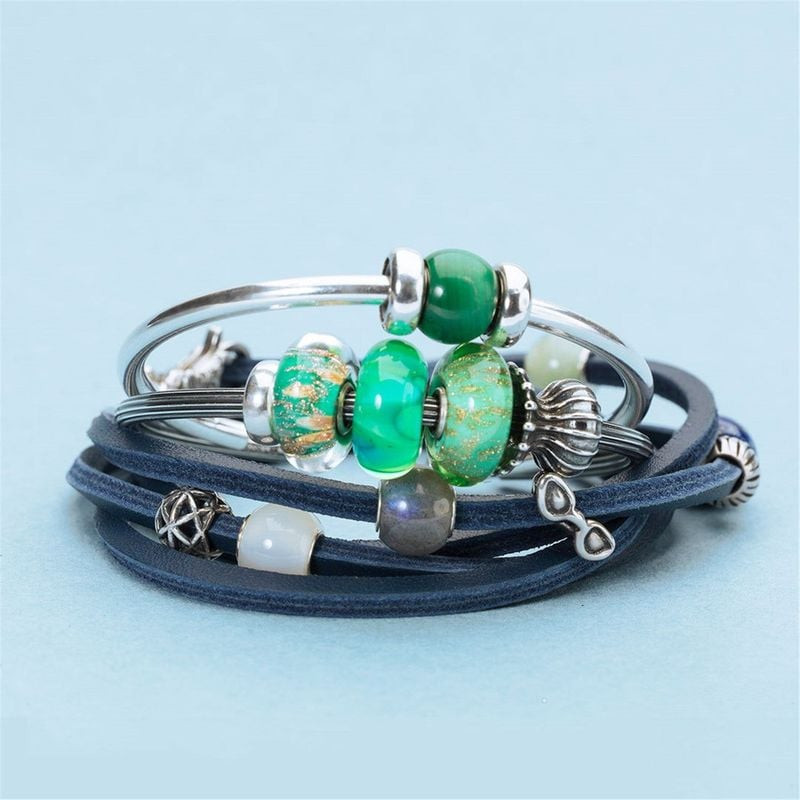 Collection de perles de verre Trollbeads dont Fonds marins sur bracelets en cuir bleu et en argent