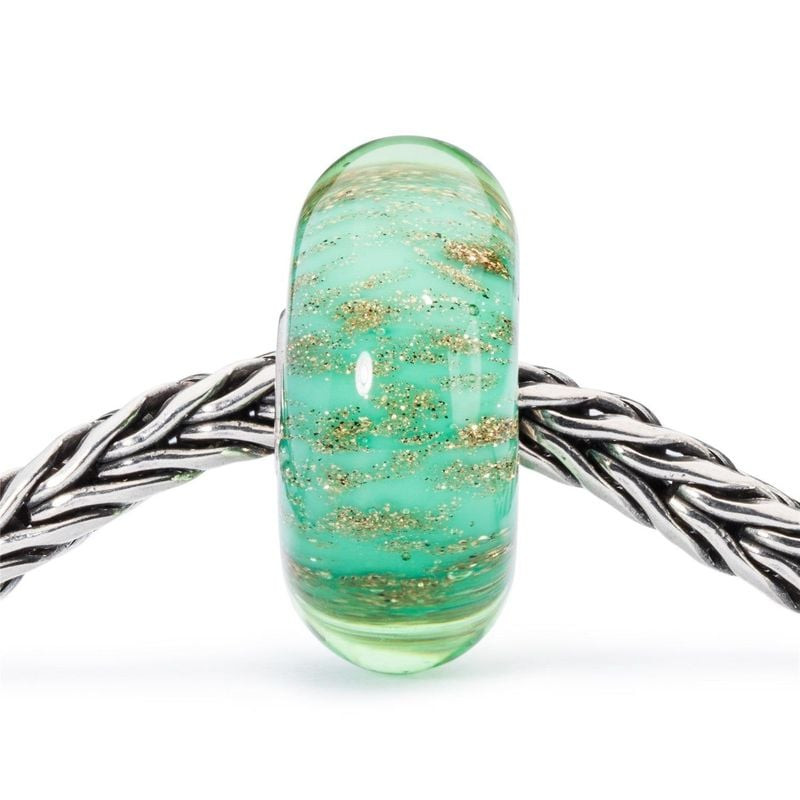 Perle de verre Trollbeads Fonds marins enfilée sur un bracelet Trollbeads en argent tressé, fond bla