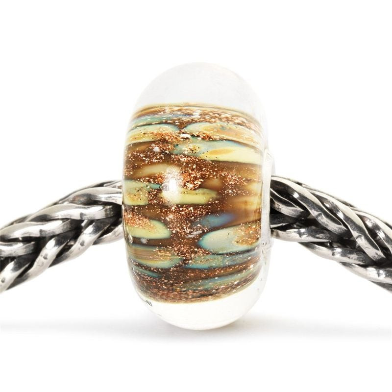 Perle de verre Trollbeads Lampe Magique enfilée sur une chaîne en argent, dévoilant sa lueur chaleur