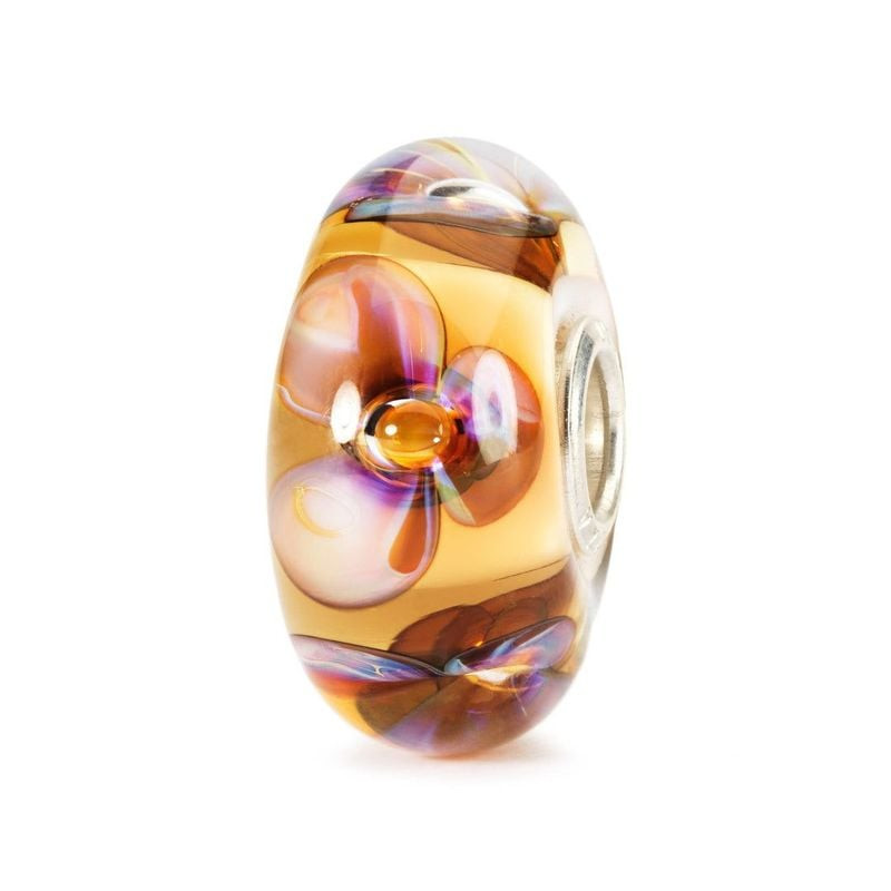 Perle Trollbeads Violettes ambre ornée de fleurs violettes sur ambre chaud, vue de côté