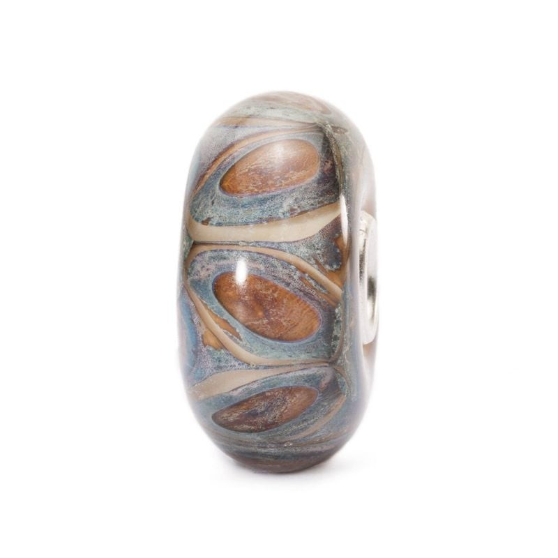 Perle en verre Trollbeads Grès vue sous un deuxième angle, montrant des volutes brun rouille et bleu