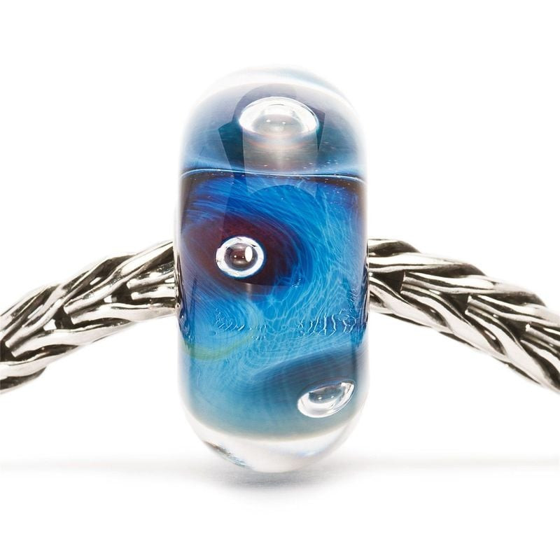 Perle Trollbeads L'Œil en verre bleu enfilée sur un bracelet Trollbeads en argent tressé, vue de fac