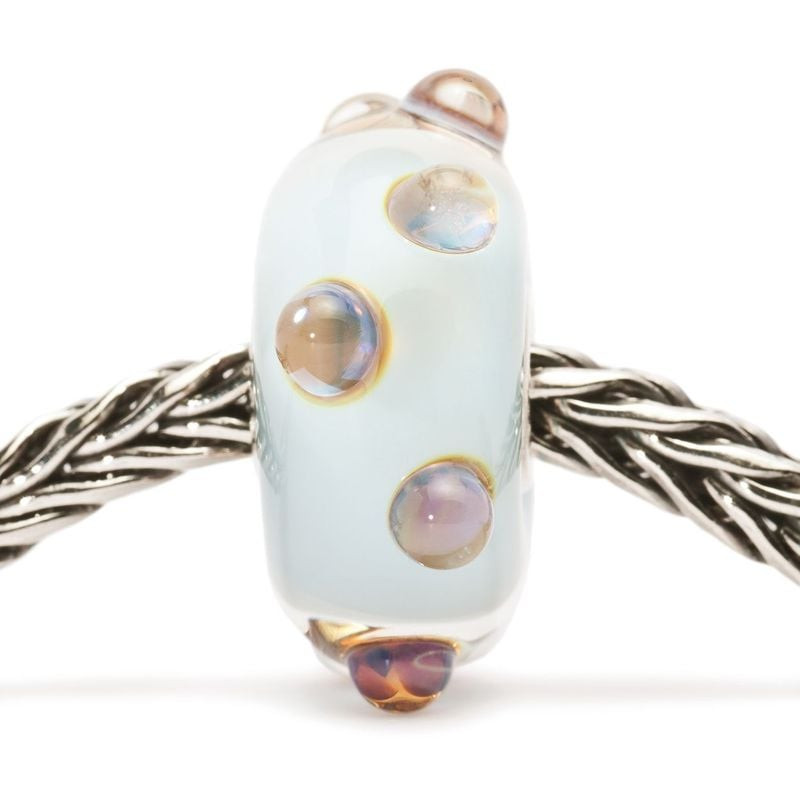 Perle Trollbeads en verre pierre de lune bleue enfilée sur bracelet argent, points iridescents et fi