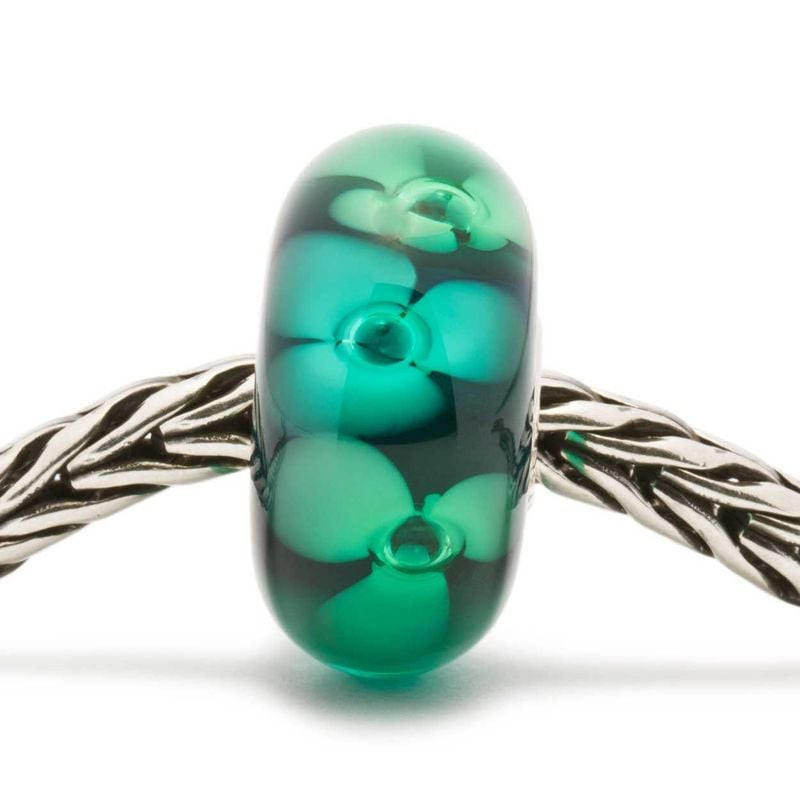 Perle Trollbeads Fleurs des bois en verre vert enfilée sur une chaîne de bracelet argent Trollbeads.