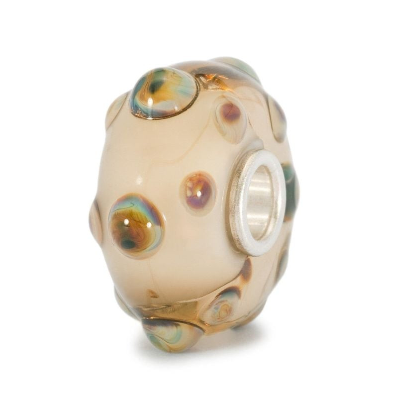 Perle Oursin Trollbeads en verre sable crème clair, reliefs iridescents, fond blanc