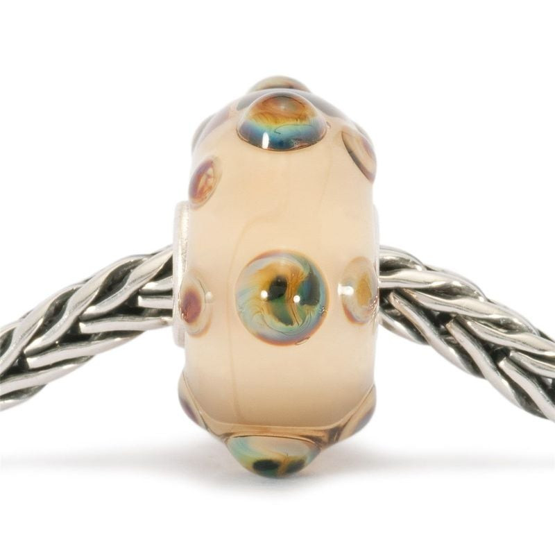 Perle en verre Trollbeads Oursin enfilée sur une chaîne Trollbeads en argent, verre crème et points 