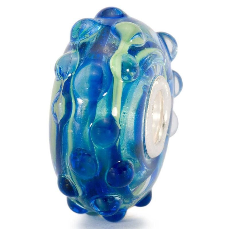 Packshot de la perle Trollbeads Écume en verre de Murano bleu et blanc sur fond neutre.