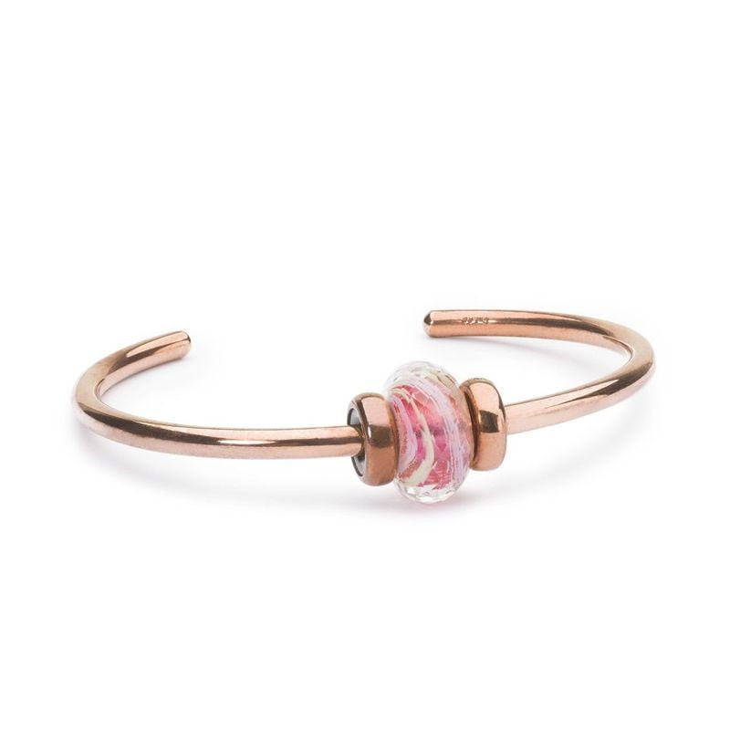 Jonc Trollbeads en cuivre avec une perle en verre spiralée rose et blanc entre arrêts en cuivre