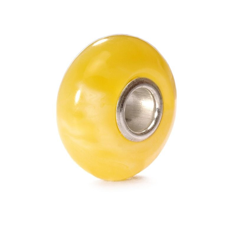 Vue de côté d'une perle Trollbeads Albâtre en verre jaune translucide avec un cœur en argent poli su