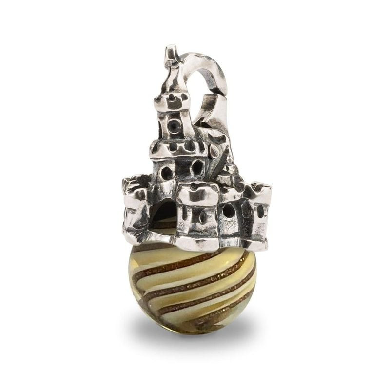 Pendentif Château de sable Trollbeads en argent et verre, vue de côté sur fond blanc, volutes dorées