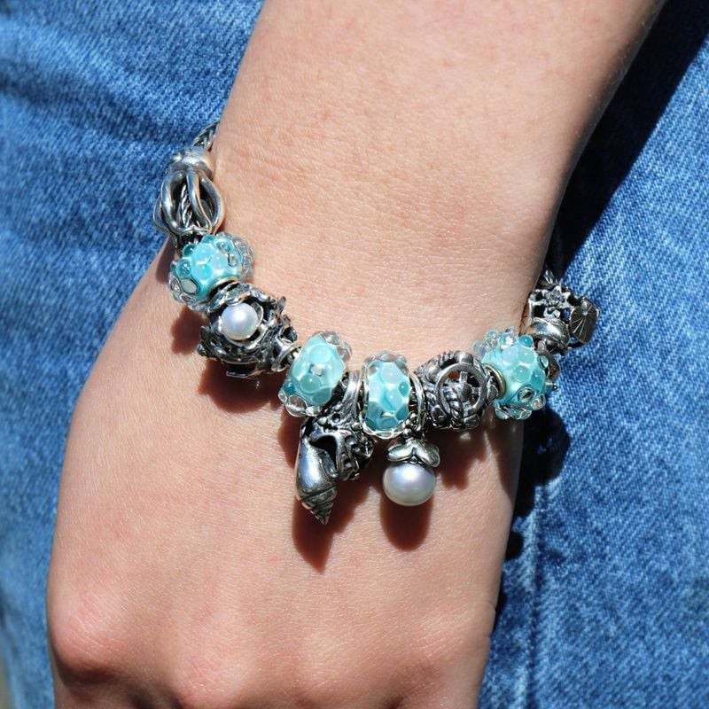 Pendentif Trollbeads Coquille Océan Argenté porté sur un bracelet Trollbeads, ambiance marine