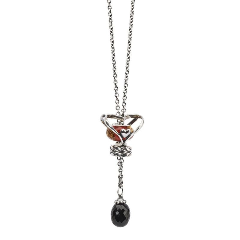 Gros plan sur un pendentif cœur en argent avec une perle rouge et une pierre d'onyx noir facettée su