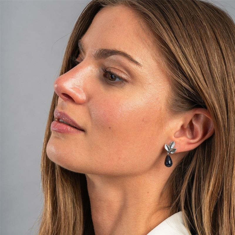 Profil d'une femme portant une boucle d'oreille Trollbeads Feuilles de Force, feuilles argentées et 