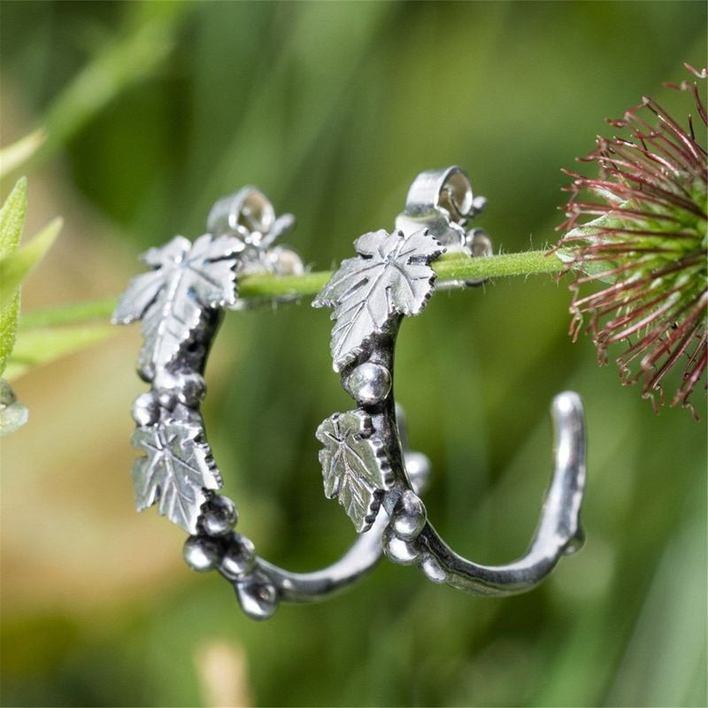 Boucles d'oreilles Trollbeads Merriness Vigne Argenté portées par un mannequin dans un décor naturel