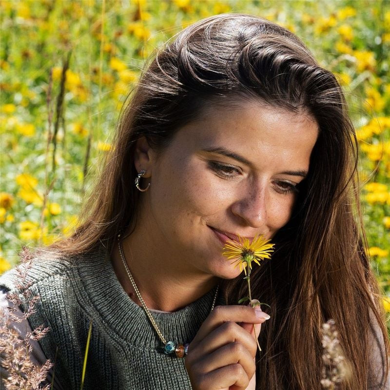 Femme portant les Boucles d'oreilles Trollbeads Merriness Vigne Argenté dans un cadre naturel.