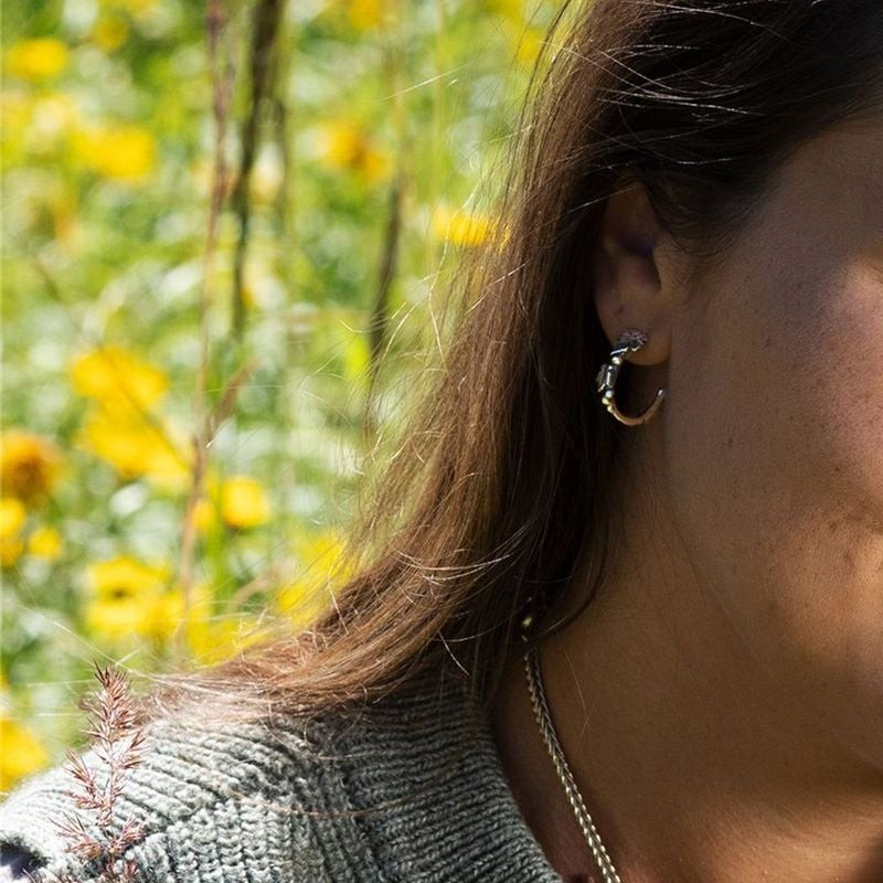 Femme portant les Boucles d'oreilles Trollbeads Merriness Vigne Argenté, élégance naturelle.