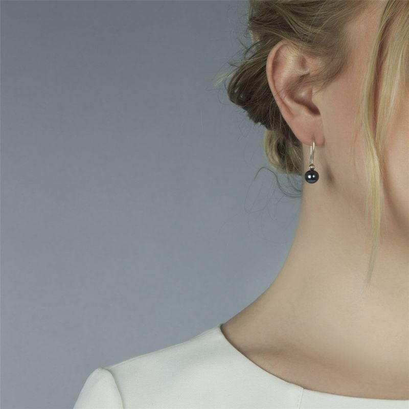 Gros plan sur le cou et l'oreille d'une femme, mettant en valeur une boucle d'oreille Trollbeads Per