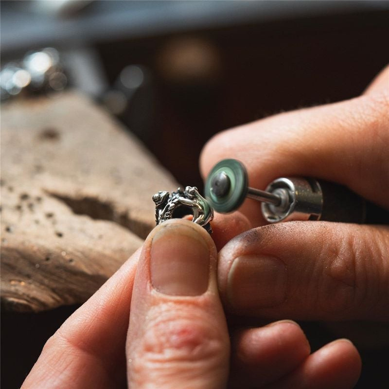 Perle Trollbeads Valse des Nénuphars Argenté posée sur une feuille de nénuphar, ambiance naturelle e