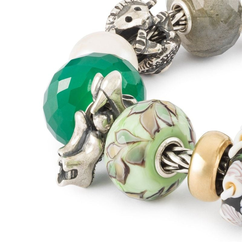 Perle à charms TROLLBEADS Foulées Vitales intégrée à un bracelet avec d'autres perles colorées.