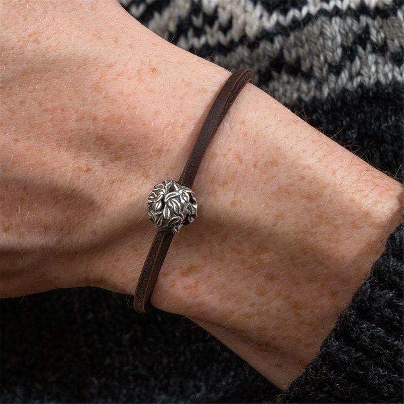 Image lifestyle en gros plan de la Perle Arbre de la Vie Argenté TROLLBEADS sur un bracelet en cuir 