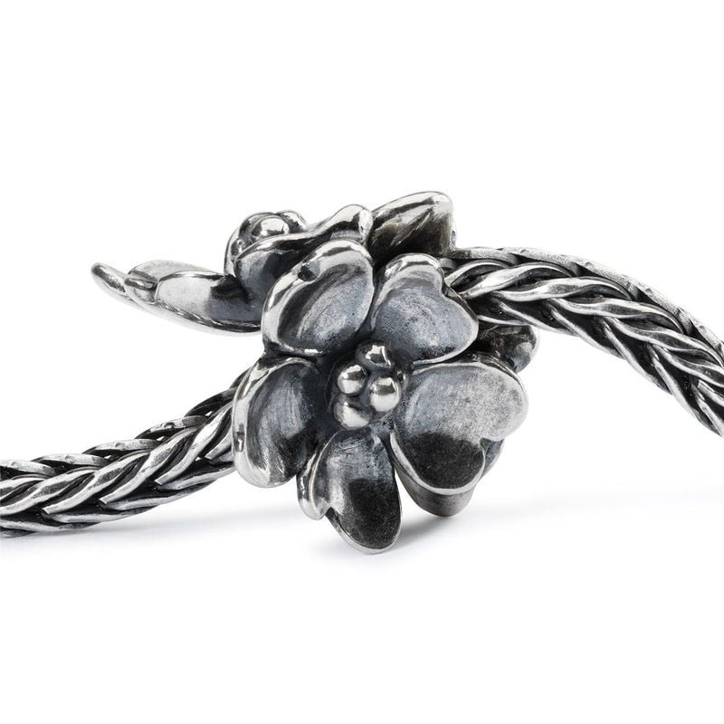 Perle de charme argentée Pommier en fleurs enfilée sur une chaîne Trollbeads tressée, vue de près