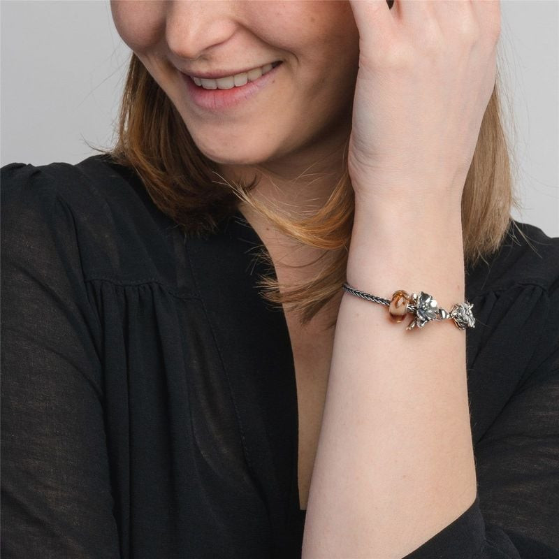 Femme portant un bracelet Trollbeads avec la perle Pommier en fleurs en argent à son poignet