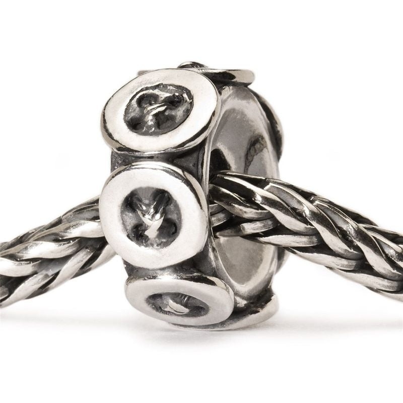 Perle Trollbeads Boutons en argent, enfilée sur un bracelet Trollbeads tressé, motif bouton et finit