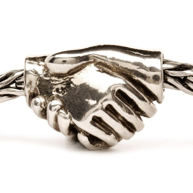 Perle Trollbeads Amitié en argent représentant une poignée de main, enfilée sur un bracelet Trollbea