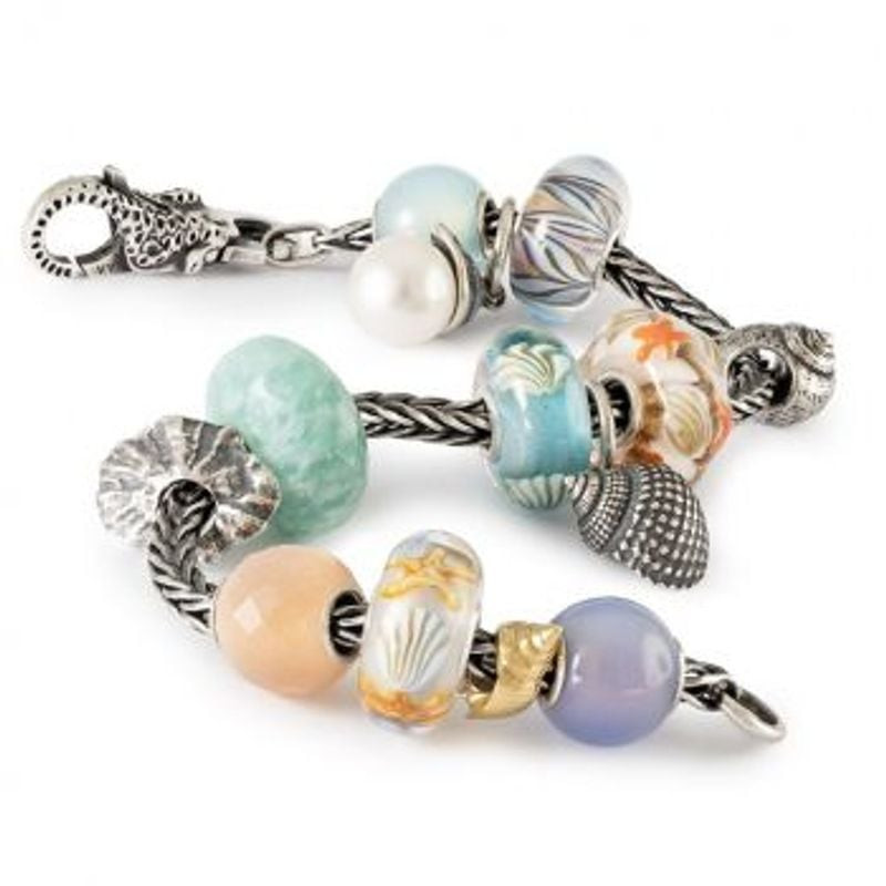 Image d'ambiance mettant en scène la Perle Trollbeads Pompon Lié à la Vague Argenté, inspirée par l'